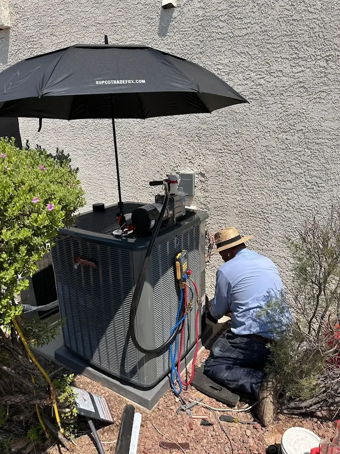 HVAC technician performing outdoor AC maintenance in Dennis